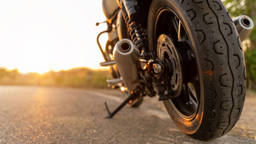 Closeup of motorcycle on road with the sun setting