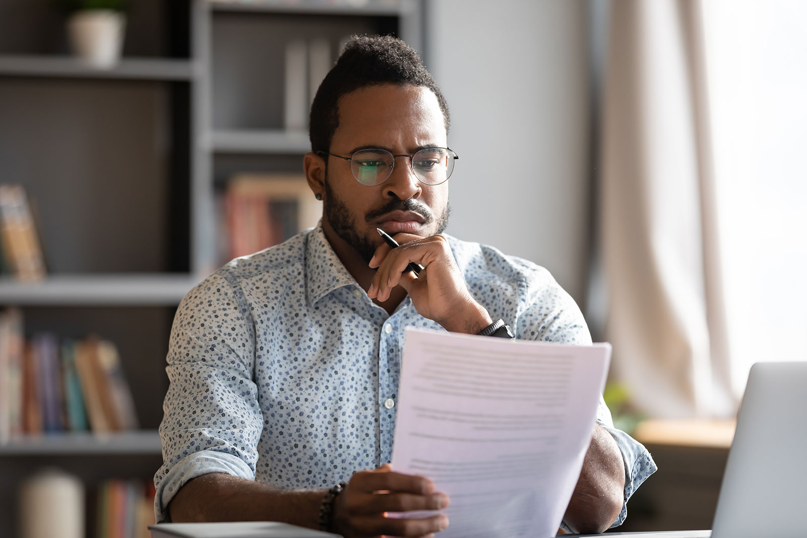 Young adult gentleman reading through an employment agreement contract